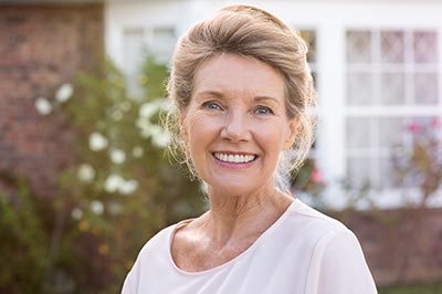 woman smiling after receiving dental implants